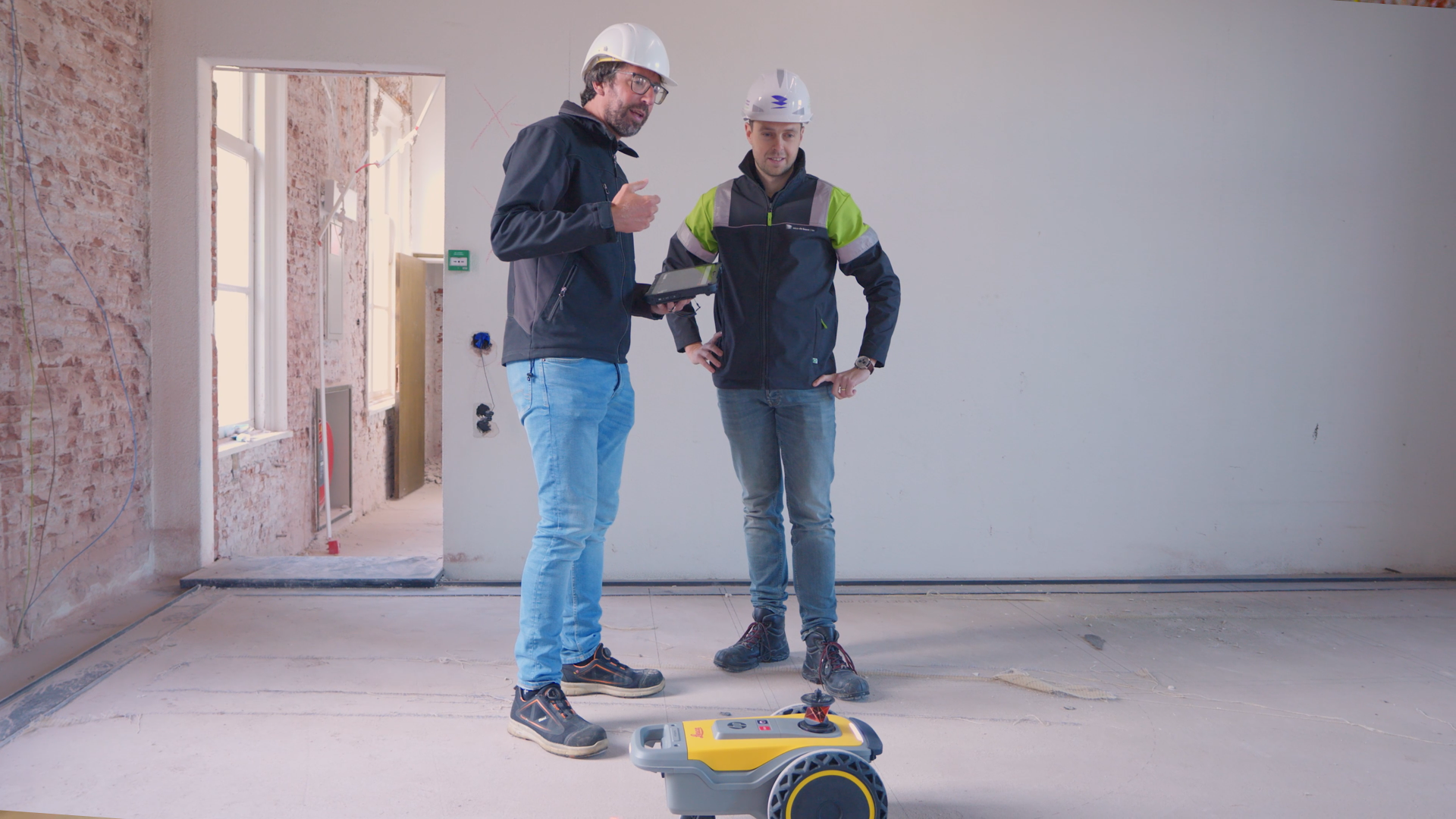 Medewerker PelserHartman met een andere man aan het uitzetten met de HP SitePrint vloerprinter op een bouwplaats tijdens een Pilotproject. 